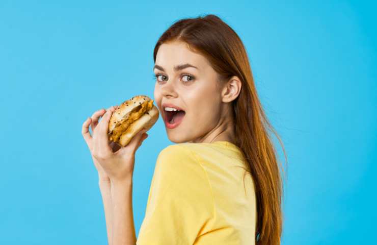 ragazza mangia un panino