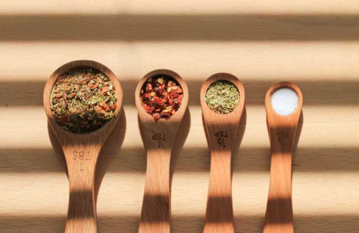spezie nei cucchiai di legno